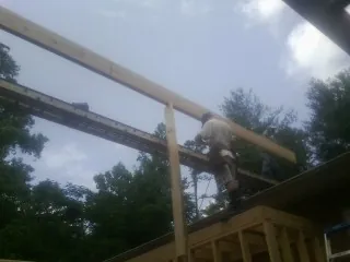 Carpenter setting a ridge beam over a new addition frame — Ice Dam Removal by Roofing Brothers in Sedalia